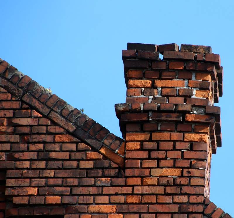 Damaged chimney on an Boca Raton home showing cracks and missing mortar